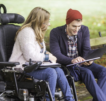 two people outsite reading on a tablet